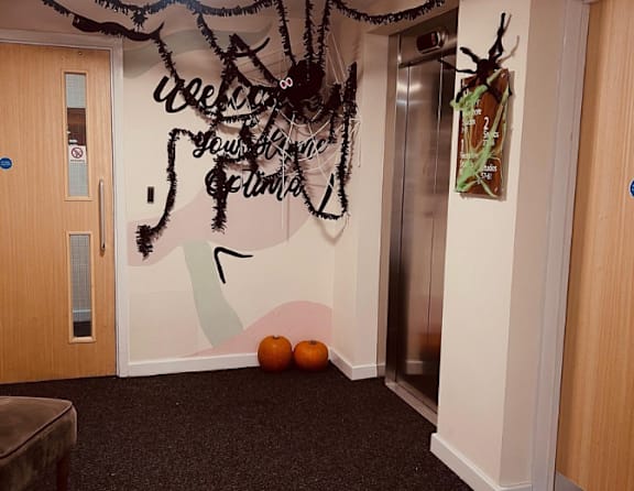 A hallway with a sign that says "Welcome to our new home" and a painting of a deer on the wall.
