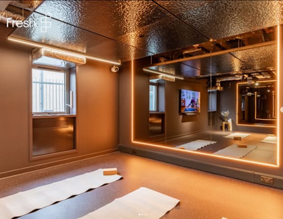 A yoga studio with a large mirror and a window.
