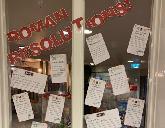 Roman resolutions written on pieces of paper are displayed on a window.