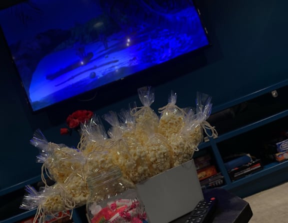 A bowl of popcorn sits in front of a television.