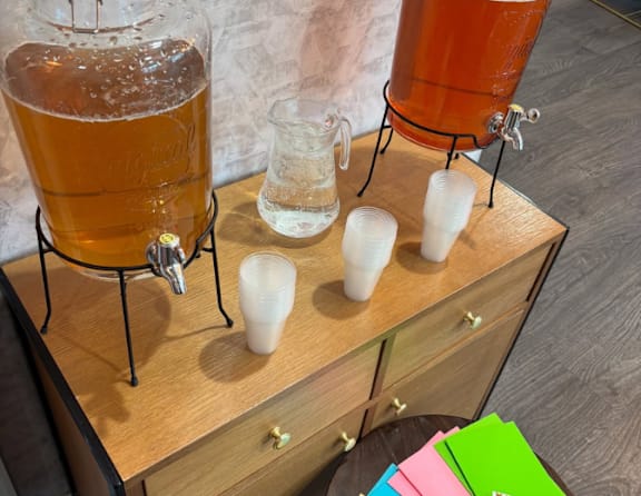 A wooden table with a beer keg and glasses on it.