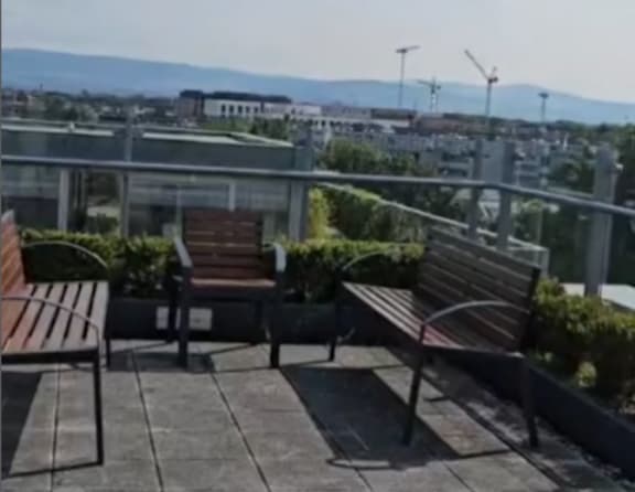 A patio with three benches and a table.