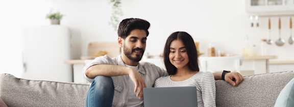 Young couple on couch with computer