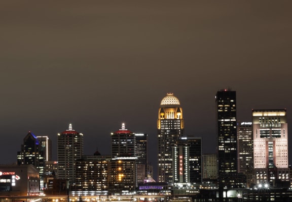a city street at night with a tall building and a city skyline at Current812, Clarksville, IN 47129