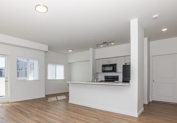 A spacious room with wooden floors and white walls.
