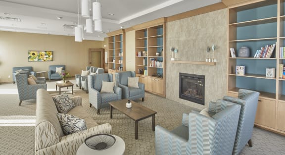 A sitting room filled with couches and a fireplace with a bookshelf.