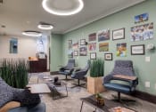 Thumbnail 3 of 5 - a living room with chairs and a table and a wall with pictures at Proximity at ODU, Norfolk, Virginia