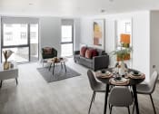 Thumbnail 2 of 12 - a living room and dining room with a table and chairs