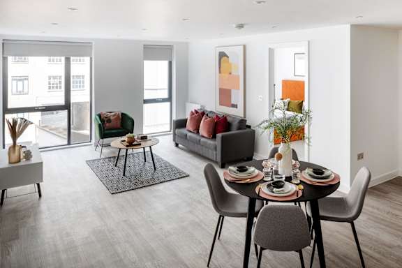 a living room and dining room with a table and chairs