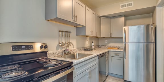 a kitchen with white cabinets and granite countertops