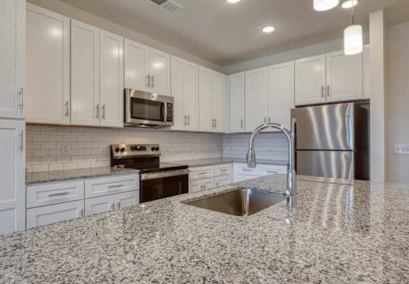 a kitchen with granite counter tops and white cabinets at The Walker Virginia Center, Glen Allen, VA, 23059