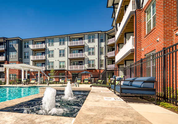 A pool with a fountain in the middle of it.