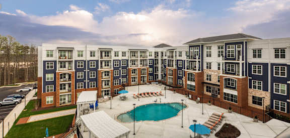 an aerial view of an apartment building with a swimming pool at The Bella at Westchester, Midlothian, VA