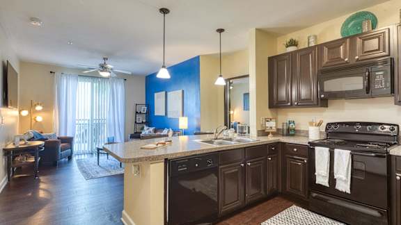 A kitchen with dark brown cabinets and a black stove top oven.