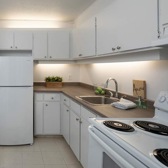 A kitchen with white appliances and a wooden table.