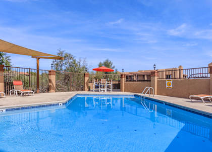 A large swimming pool with a sun lounger and umbrella.