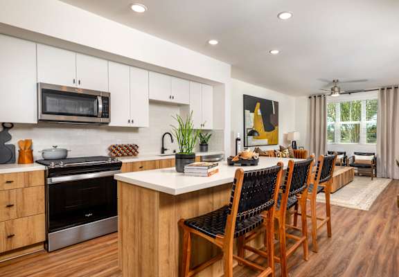 A modern kitchen with wooden floors and a large island.
