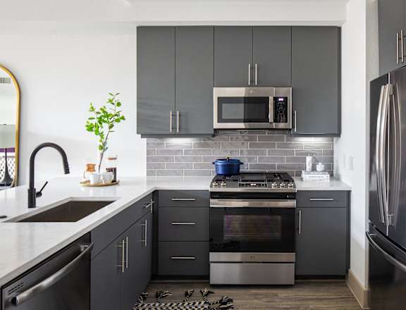 a kitchen with stainless steel appliances and black cabinets