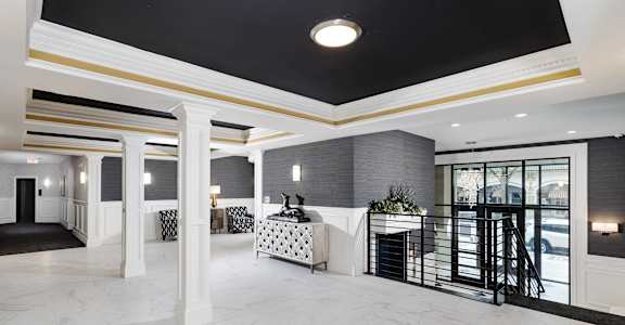 a large marble lobby with a reception desk and a balcony