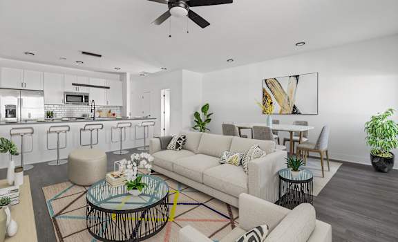 A modern living room with a glass coffee table and a white sofa.