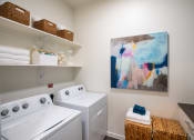Thumbnail 19 of 19 - a washer and dryer in a laundry room with a painting on the wall