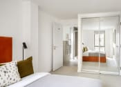 Thumbnail 11 of 12 - a bedroom with a bed and a mirror