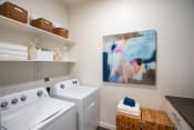 Thumbnail 19 of 19 - a washer and dryer in a laundry room with a painting on the wall