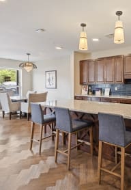 a kitchen with a large island and a stainless steel refrigerator