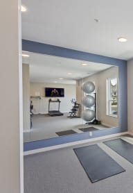 a fitness room with yoga mats and a large window