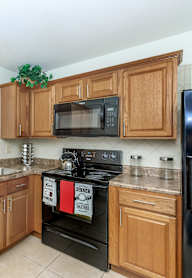 A kitchen with wooden cabinets and black appliances.
