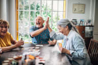 a man and a woman are sitting at a table with cards in front of them