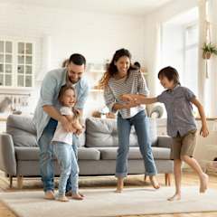 A family of four is playing a game in their living room.