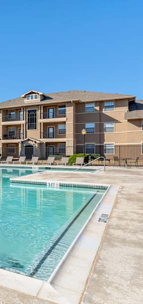 A large swimming pool in front of apartment buildings.