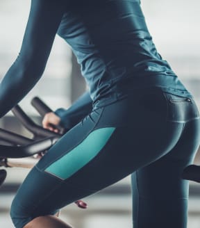 a woman riding an exercise bike in a gym