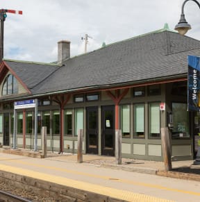 a train station with a train on the tracks in front of it