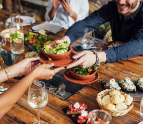 a group of people sitting around a table eating food