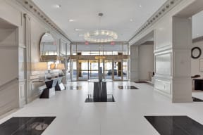 a lobby with a white tiled floor and a chandelier