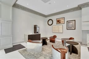 a living room with chairs and a table and a desk