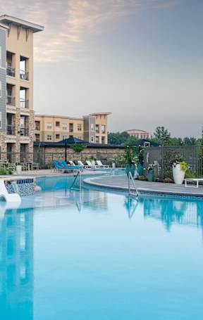 A large swimming pool in front of apartment buildings.