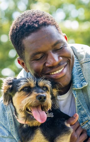 a man holding his dog in a park