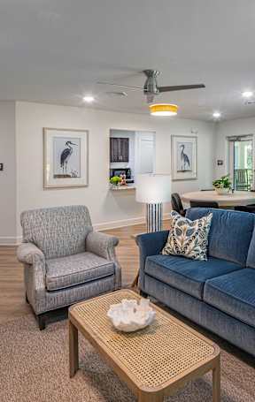 A living room with a blue couch and a grey armchair.