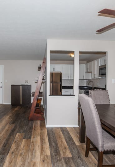 a living room and dining room with hardwood floors and a ceiling fan