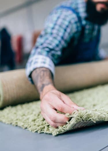 a man rolling out a carpet on a table