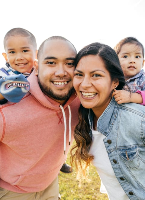 Man and woman with two children in a park at Brookwood at Islip in Islip, NY 11751