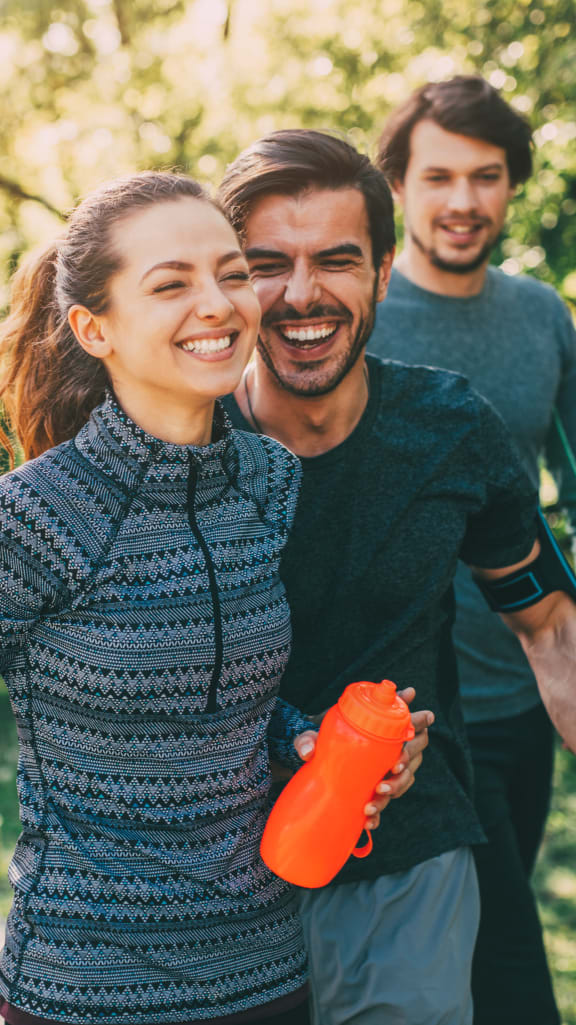 a group of people walking in the park with an orange water bottle at Midtown Sam Houston Apartments, Huntsville, TX, 77340