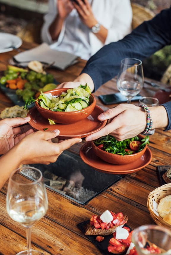 a group of people sitting around a table eating food