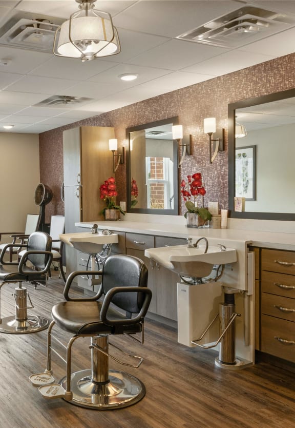 a salon room with chairs and sinks and mirrors