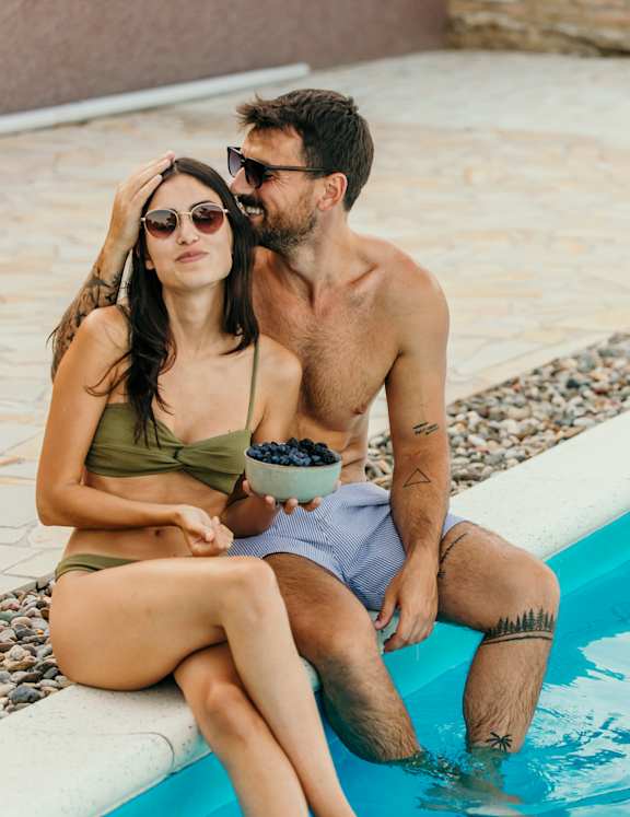 a woman laying in a pool with her legs in the water
