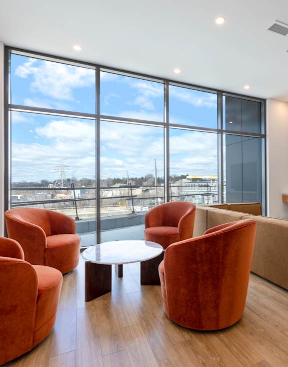 A living room with a large window, a sofa, a chair, a coffee table, and a television.