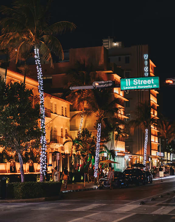 A street view of a lit up building with a sign that says 11th street.